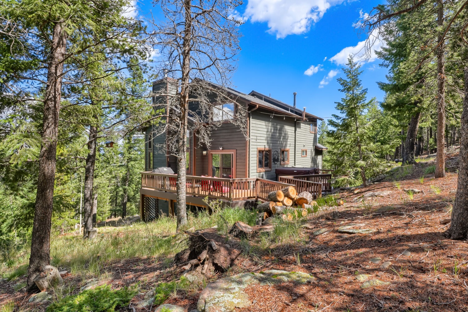 Rear of home with deck and mountain backdrop