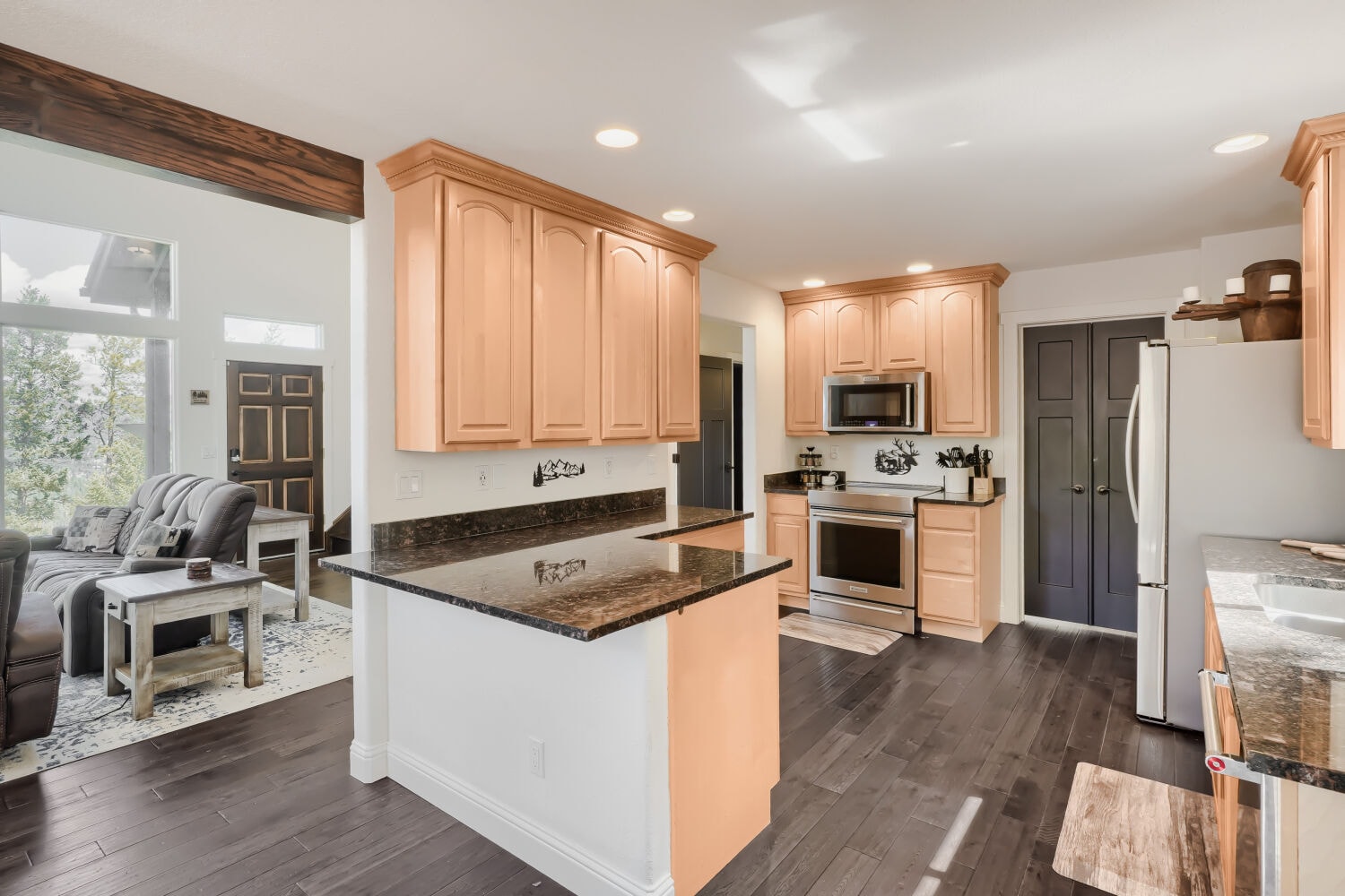Lower level kitchen and living area — fully equipped with dark cabinetry and modern finishes